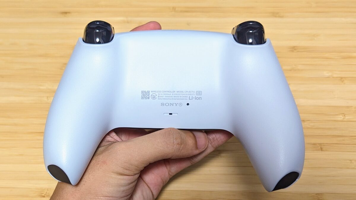 ホワイトのDualSenseを手で持ち背面のグリップ形状が見える本人レビューの実機写真